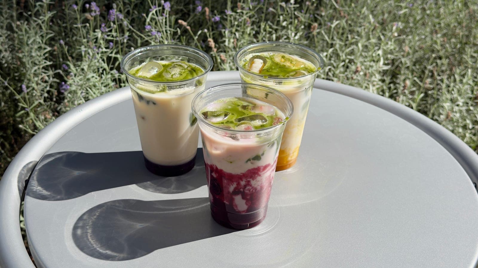 Three drinks with a fruit layer in the sun
