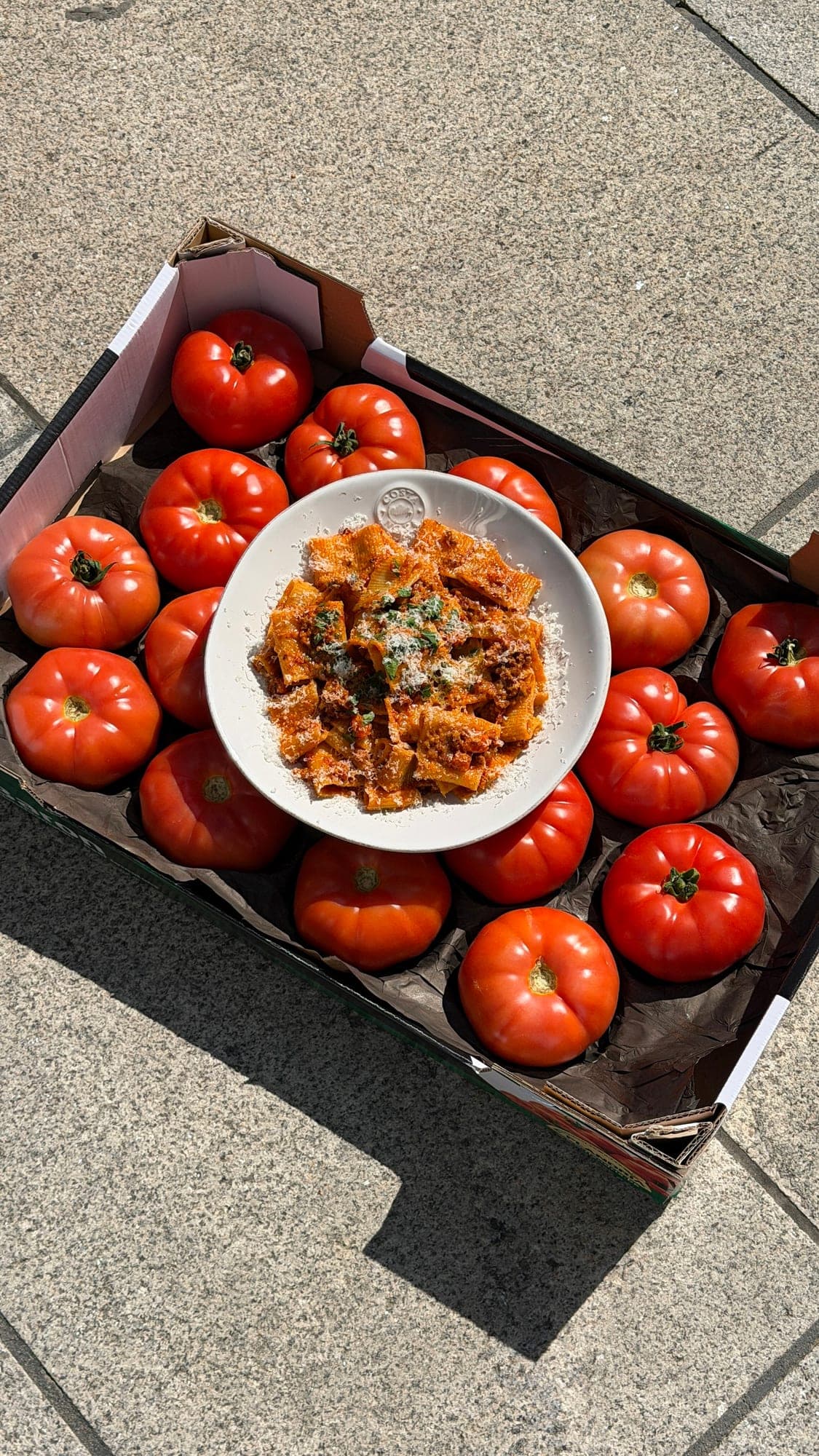 Pasta in tomato sauce in a crate full of tomatoes