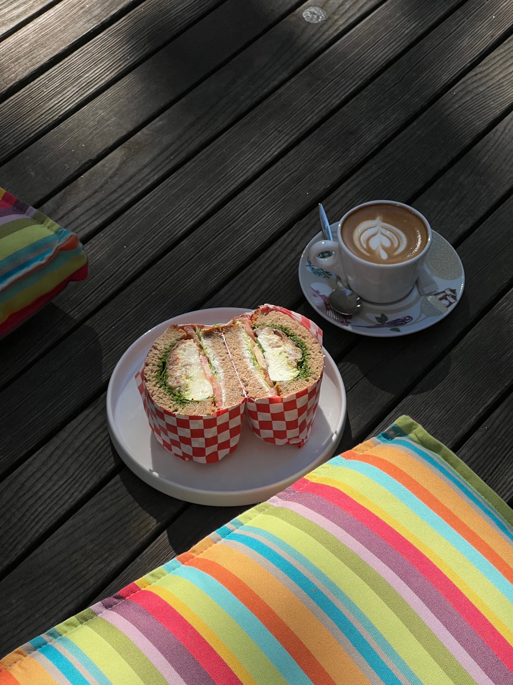 Sandwich and cappuccino on the wooden table