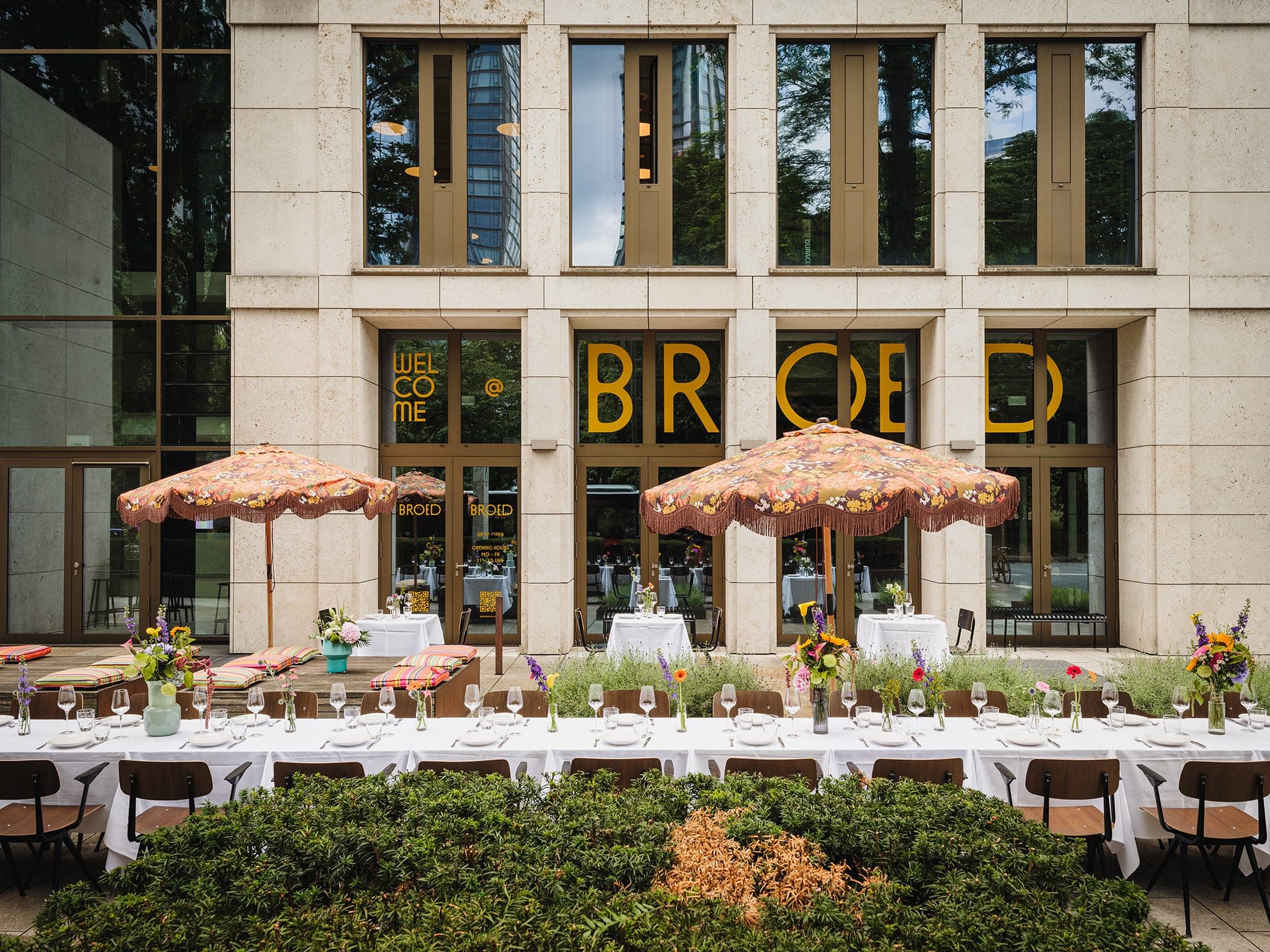 Lange gedeckte Tafel vor der BROED-Fassade