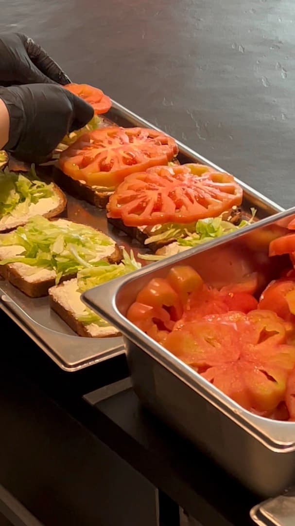 Bleche mit Broten und Tomaten bei der Zubereitung